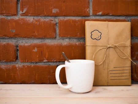 Cup of coffee with gift box on wooden table. Side viewの写真素材