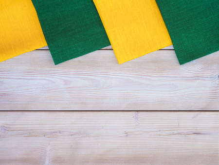 Yellow and green tablecloths on wooden tableの写真素材