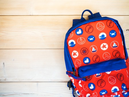 Children's backpack on the wooden board. Nautical theme. View from aboveの写真素材