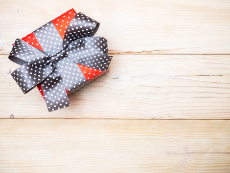 Birthday present with gray satin tape on wooden board. Holidays conceptの写真素材