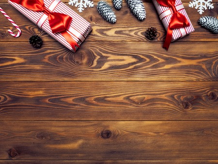 Composition of packed present boxes with pine cones, snowflakes and lollypop on wooden board. Celebrations conceptの写真素材