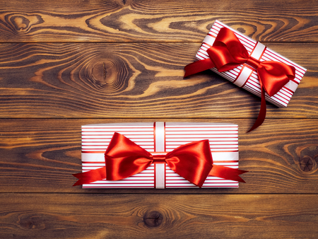 Gift boxes with red-white ribbons on wooden board. Holidays conceptの写真素材