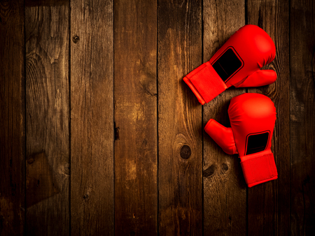 Pair of leather karate gloves lying on the wooden tableの写真素材