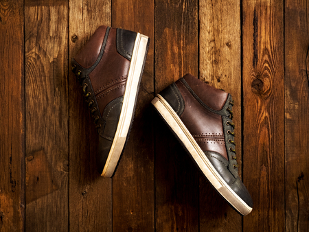 Pair of leather boots lying on the wooden table