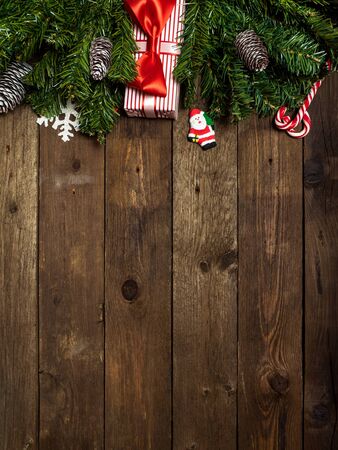 Christmas background. Fir branches with cones on the wooden background. Top view. Holiday conceptの写真素材