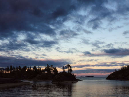 Silhouettes of small islands against the backdrop of the sunset sky. Lake Ladoga. Republic of Karelia, Russiaの写真素材