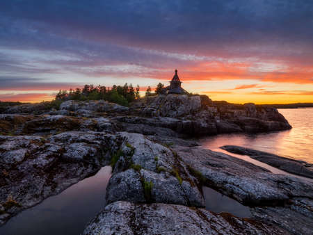 A lone church in the middle of the island in the rays of the setting sun. Lake Ladoga. Republic of Karelia, Russiaの写真素材