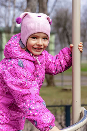 Little happy girl is playing on the kid's playgroundの写真素材