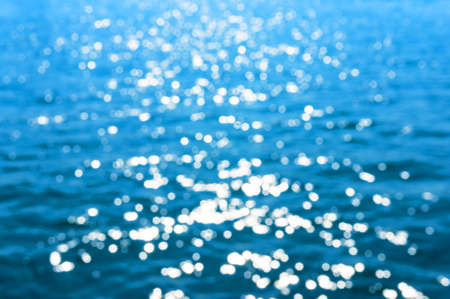 Abstract bokeh of glittering water texture. Blurred nature texture, background