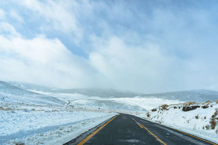 Australian winter landscape of snow covered filends and ice-covered road. Snowy Mountains, Australiaの写真素材
