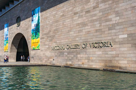 Melbourne, Australia - April 18, 2017: National Gallery of Victoria entrance door with colorful banners of new exhibition and water pool on the foregroundのeditorial素材