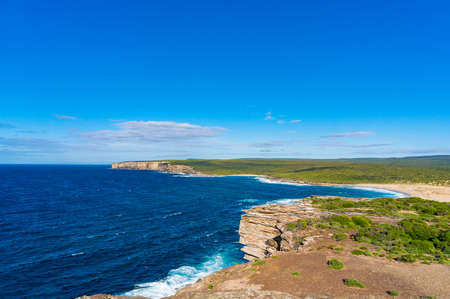 Picturesque panoramic view of ocean coastline with blue water and sunlit beachの写真素材