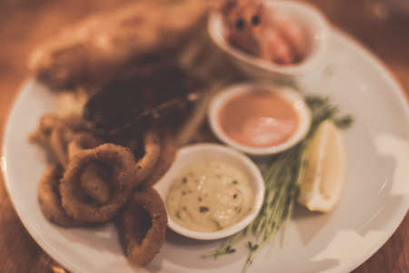 Food background of seafood with sauce and fresh herbs. Tinted image with soft focus and muted vintage colorsの写真素材