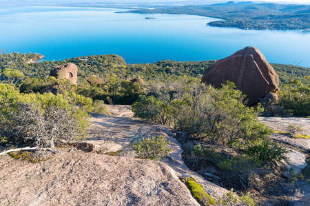 View on steep mountain slope and beautiful lagoon and mountains underneath. Tasmania, Australiaの写真素材