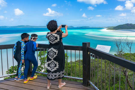 Whitsundays, Australia - February 5, 2017: Woman taking picture of beautiful tropical lagoon with her smartphone at Hill inlet lookoutのeditorial素材