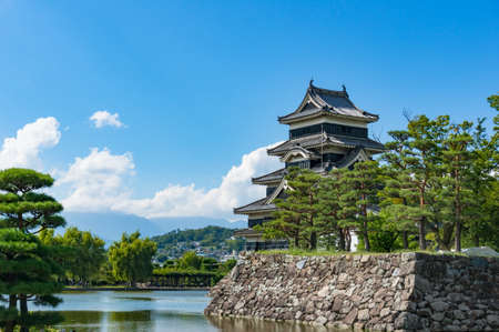 Matsumoto castle with pine trees on foreground on sunny day. Matsumoto, Japanのeditorial素材