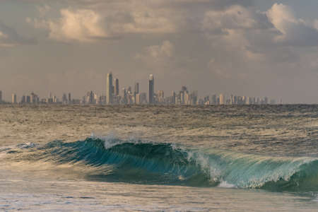 Large waves with Gold Coast cityscape skyline on the backgroundのeditorial素材