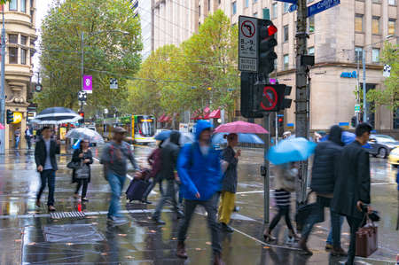Melbourne, Australia - April 21, 2017: Pedestrians on traffic lights on intersection of Collins and Elizabeth streets on rainy dayのeditorial素材
