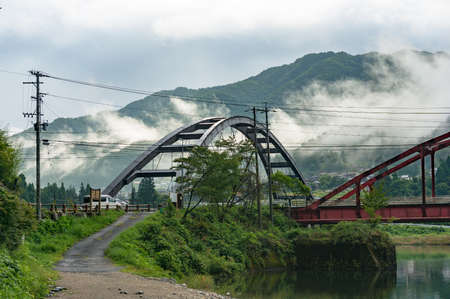 Landscape of bridge with mountain and low clouds on the background. Kiso valley, Nagano, Japanのeditorial素材