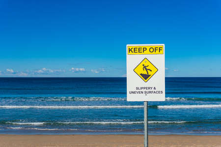 Keep out warning beach sign against ocean and blue sky on the backgroundの写真素材