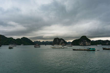 Ha Long Bay, Vietnam - August 13, 2017: Cruise ships and cruise boats in Halong Bay with dramatic overcast sky on the backgroundのeditorial素材