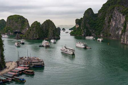 Ha Long Bay, Vietnam - August 13, 2017: Pier and bay with cruise ships and cruise boats near Surprise Cave. Halong Bay, Vietnamのeditorial素材