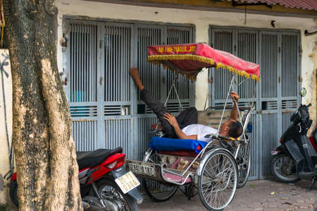 Hanoi, Vietnam - August 12, 2017: Cyclo, bike cab driver sleeping on the streetのeditorial素材