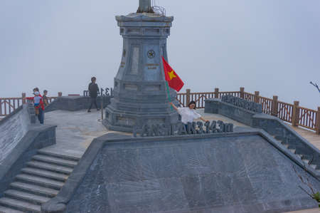 SaPa, Vietnam - August 20, 2017: Asian tourists with Vietnamese flag on Fansipan mountain summitのeditorial素材