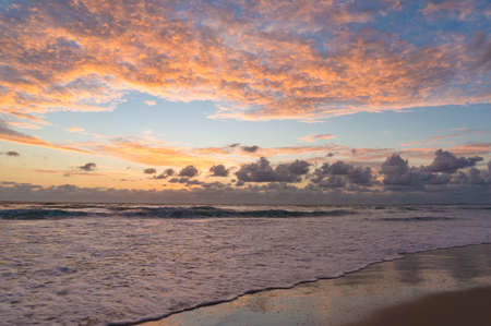 Picturesque ocean beach with soft waves on sunrise, sunset nature backgroundの写真素材