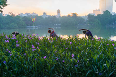 Hanoi, Vietnam - August 21, 2017: Three women doing exercise on Hoan Kiem lake in the morningのeditorial素材