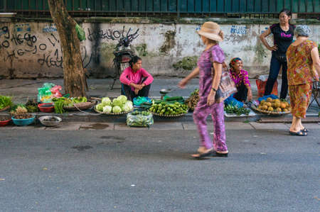 Hanoi, Vietnam - August 21, 2017: Women selling tropical fruits on the street market in Hanoiのeditorial素材