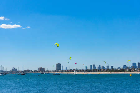 Panoramic view of St.Kilda beach with kite surfers and Melbourne cityscape on sunny dayの写真素材