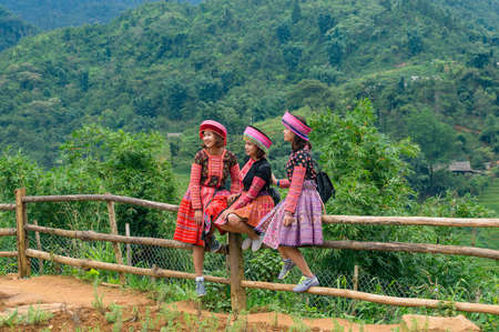 Cat Cat, Vietnam - August 20, 2017: Young women tourists posing in traditional Vietnamese dresses...