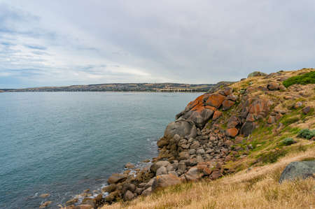 Coastline with high cliff covered with rocks and colorful lichen nature background. Granite island