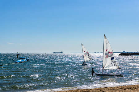 Melbourne, Australia - December 7, 2016: Sportsmen caring sailing boats after competition on St. Kilda beachのeditorial素材