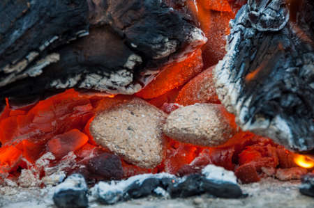 Close up of glow of embers, burning embers, charcoal, coal and wood in a fiteの写真素材