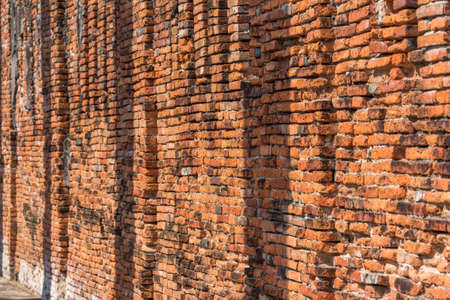 Old red brick wall perspective background. Ancient ruins of Wat Thammikarat templeの写真素材