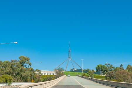 Asphalt road with Parliament House on the background on sunny day. Infrastructure, transportation in...