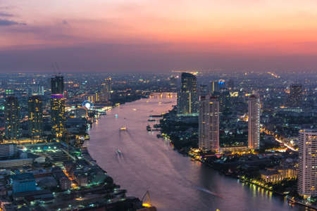 Aerial view of Bangkok cityscape at sunset with Chao Phraya river and colourful sky. Modern urban backgroundの写真素材