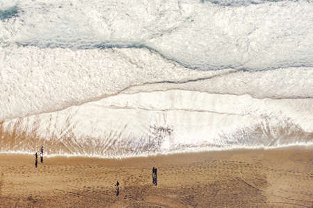 Aerial view of ocean beach with people on sand shore. Nature background
