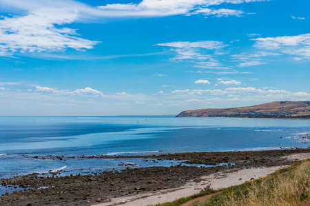 Seascape on sunny day with blue water and hill shorelineの写真素材