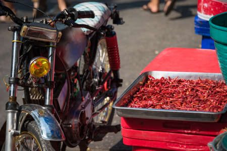 Thai street food scene with dry red chilli peper and motor bicycle. Local food backgroundの写真素材