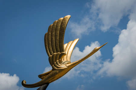 Singapore, Singapore - August 23, 2013: Statue of golden bird against blue sky on the background. Parkview Square, Singaporeのeditorial素材