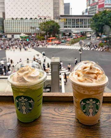 Tokyo, Japan - August 30, 2016: Two Starbucks ice coffees with view of famous Shibuya crossing in Tokyoのeditorial素材