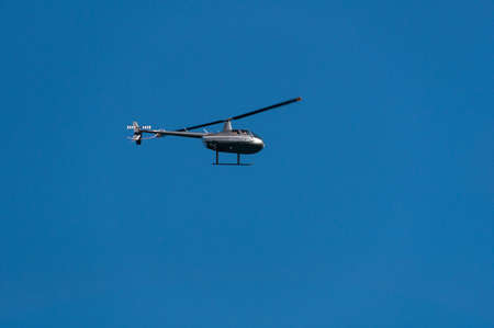 Helicopter flying against clear blue sky on the background. Air travel on chopper