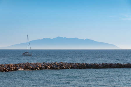 White yacht in the sea with silhouette of Corsica Island on the background. Sea travel holiday seascapeの写真素材