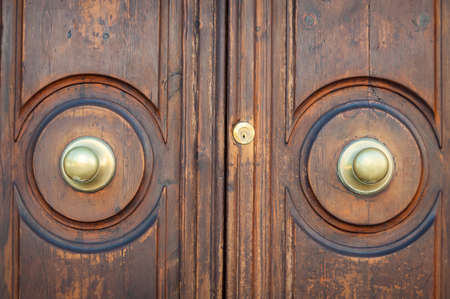 Old wooden door with golden metal door handles. Architectural details background, textureの写真素材