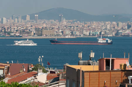 Istanbul cityscape with heavy cargo ship and cruise ship on Bosporus. Istanbul, Turkey