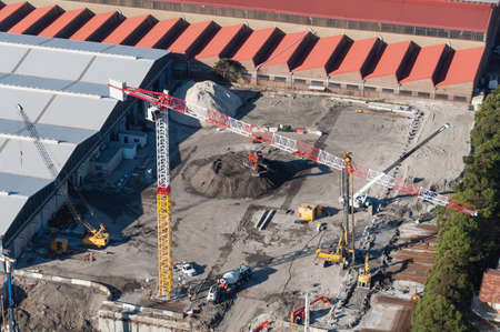 Aerial view of construction building site with heavy construction machinery. Urban development