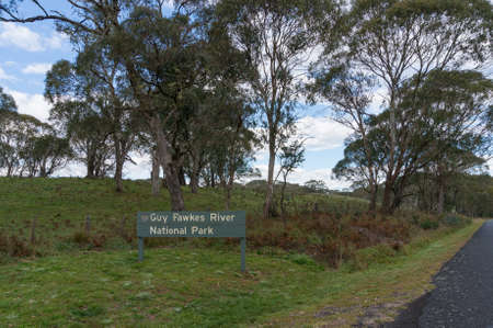 Guy Fawkes River National Park sign with eucalyptus trees on the background. Tourism infrastructure and navigation sign. Dorrigo, Australiaのeditorial素材